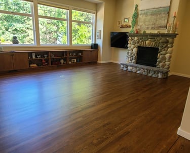 a beautiful deep brown hardwood floor with stone fireplace
