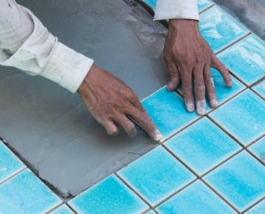 Pemasangan keramik berwarna biru oleh tukang dari Bali Pool Care