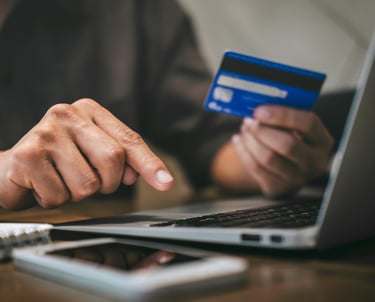 a person holding a credit card and pointing at a credit card