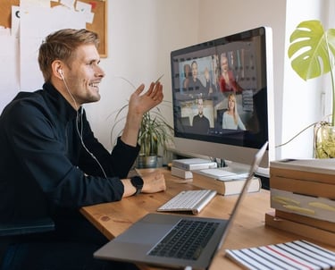 a man sitting at a desk with a laptop and a laptop