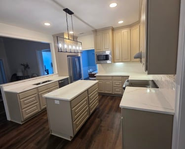 Modern kitchen featuring beige cabinets, quartz countertops, a central island, and dark wood flooring.