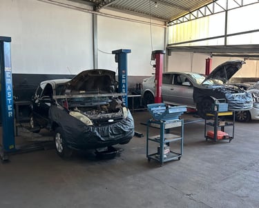 Imagem do pátio da oficina, mostrando elevadores e veículos em manutenção.
