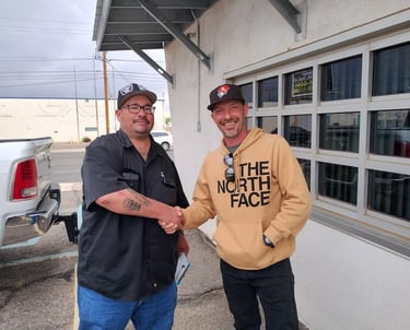two men shaking hands in front of a building