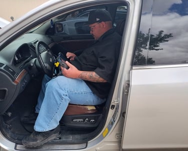a man in a black shirt is sitting in a car