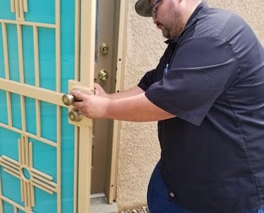 a man in a black shirt and jeans standing in front of a door