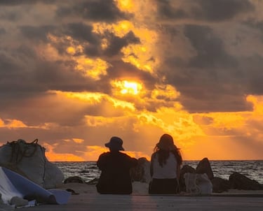 a couple of people sitting on a beach