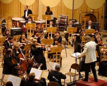 une chef d'orchestre dirige ses musiciens