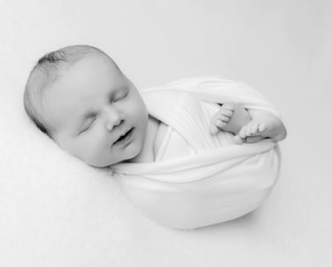 a baby is sleeping in a blanket wrapped in a blanket
