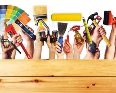 handyman holding up paint brush facuet electrical outlet spackle knife