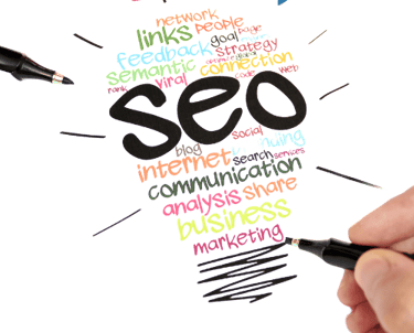 a person holding a pen and writing on a paper