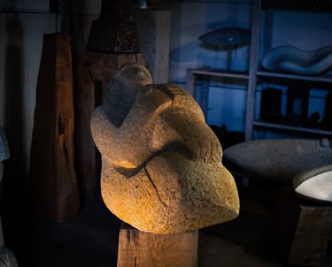 Frauenskulptur aus Stein, liegend, mit angezogenen Knien