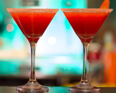 Dos cócteles de daiquiri de fresa roja en copas de martini con bordeado con sal.