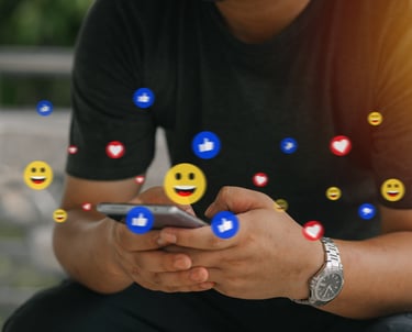 man typing on phone with emojis