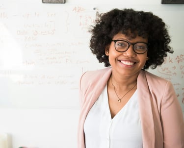 a woman in glasses and a pink jacket