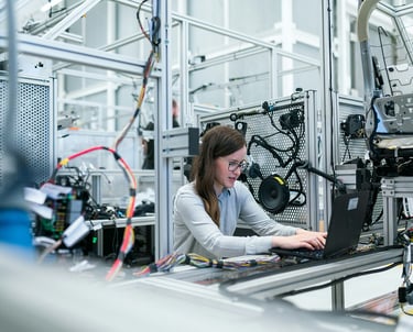 a woman in a lab coat is working on a laptop