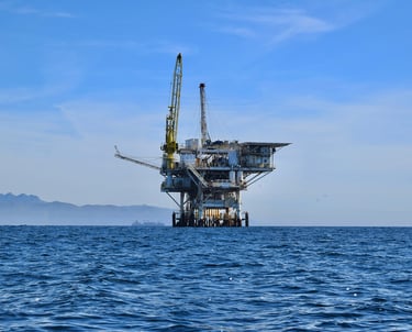 a large oil rig with a crane in the middle of the ocean