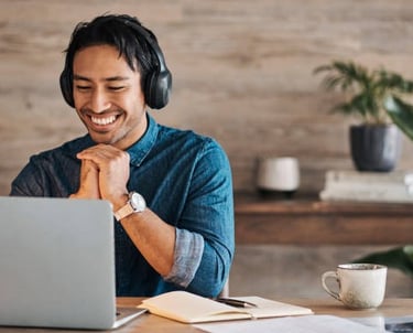 a man wearing headphones and headphones, sitting at a desk with a laptop Telehealth 