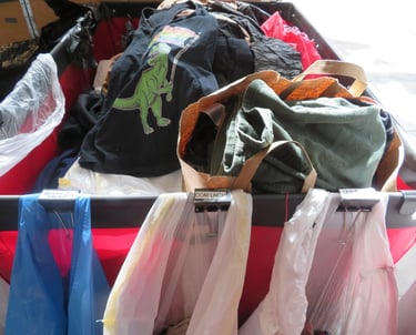 Red bin filled with bags of donations