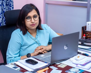 a woman sitting at a desk with a laptop computer