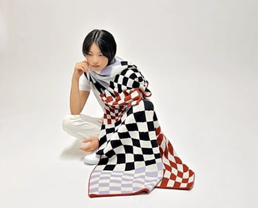 a woman covered by a checkered blanket