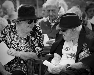Elderly couple at AnZac Day event reminiscing.