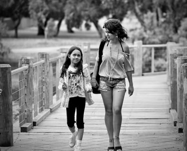 Young woman and child waling over a wooden bridge
