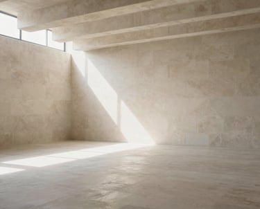 A wide architectural shot of a bright, airy studio with clean stone textures and high ceilings, soft natural light filtering through, Spanish-speaking environment.