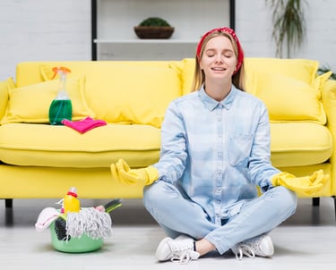 a woman sitting on a couch with a cleaning mop after a great clean services