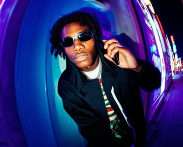 a man in a black jacket and sunglasses on phone
