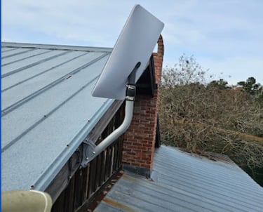 Starlink satellite internet dish mounted on a metal roof for high-speed rural connectivity.