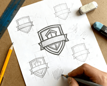 a person is drawing a logo on a piece of paper