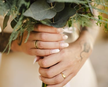 Une mariée qui tient un bouquet de fleur et son alliance