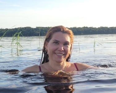 a woman in a bikini top is smiling and holding a frisbee