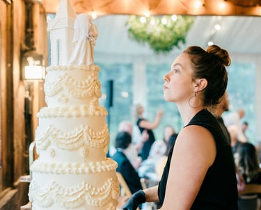 Business owner and baker putting finishing touches on a luxury vintage wedding cake