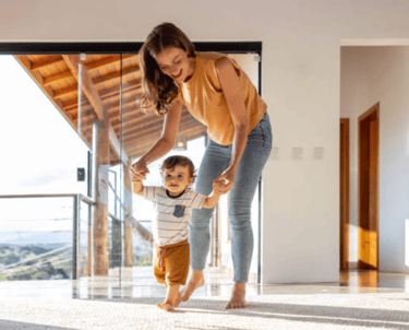 a woman holding a baby's hand while walking through a room martin pe coach de parejas
