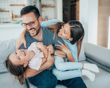 a man and woman sitting on a couch with a baby martin pe coach de parejas