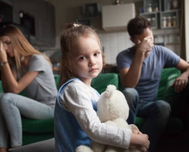 a young girl sitting on a couch with her father and mother martin pe coach de parejas