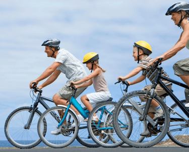 A family of four with two of them being children riding their bikes.