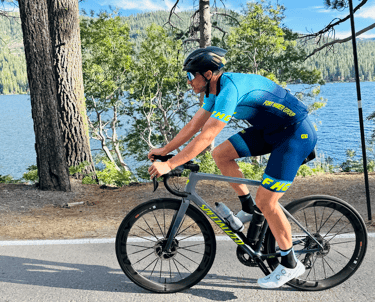 A man riding a bike next to a lake