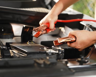 a person is holding battery jumper cables in both hands