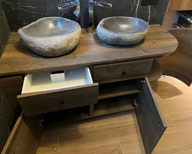 Rustic double stone vessel sinks on a dark wood vanity with modern chrome faucets.