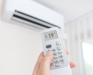 Una persona que enciende una unidad de aire acondicionado usando un control remoto