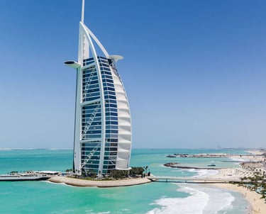 Dubai skyline with Burj Al Arab by the turquoise sea.