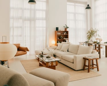 Bright and airy living room with neutral-toned furniture and large windows.