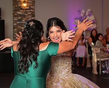two women in green dresses dancing at a wedding