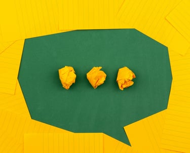 A chat bubble with three crumpled papers in the middle