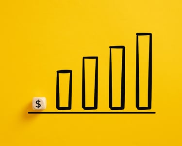 Dollar symbol on a wooden cube with an ascending graph