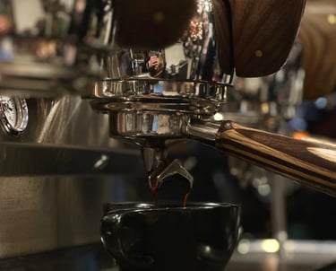 a cup of coffee being poured into a cup