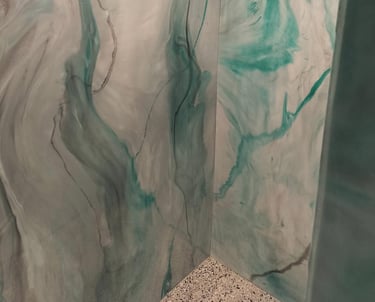 Custom epoxy shower walls with a flowing marble-like design in teal and gray tones, seamlessly