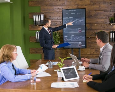 Man presenting a digital chart about Digital AI Marketing to his team in an office